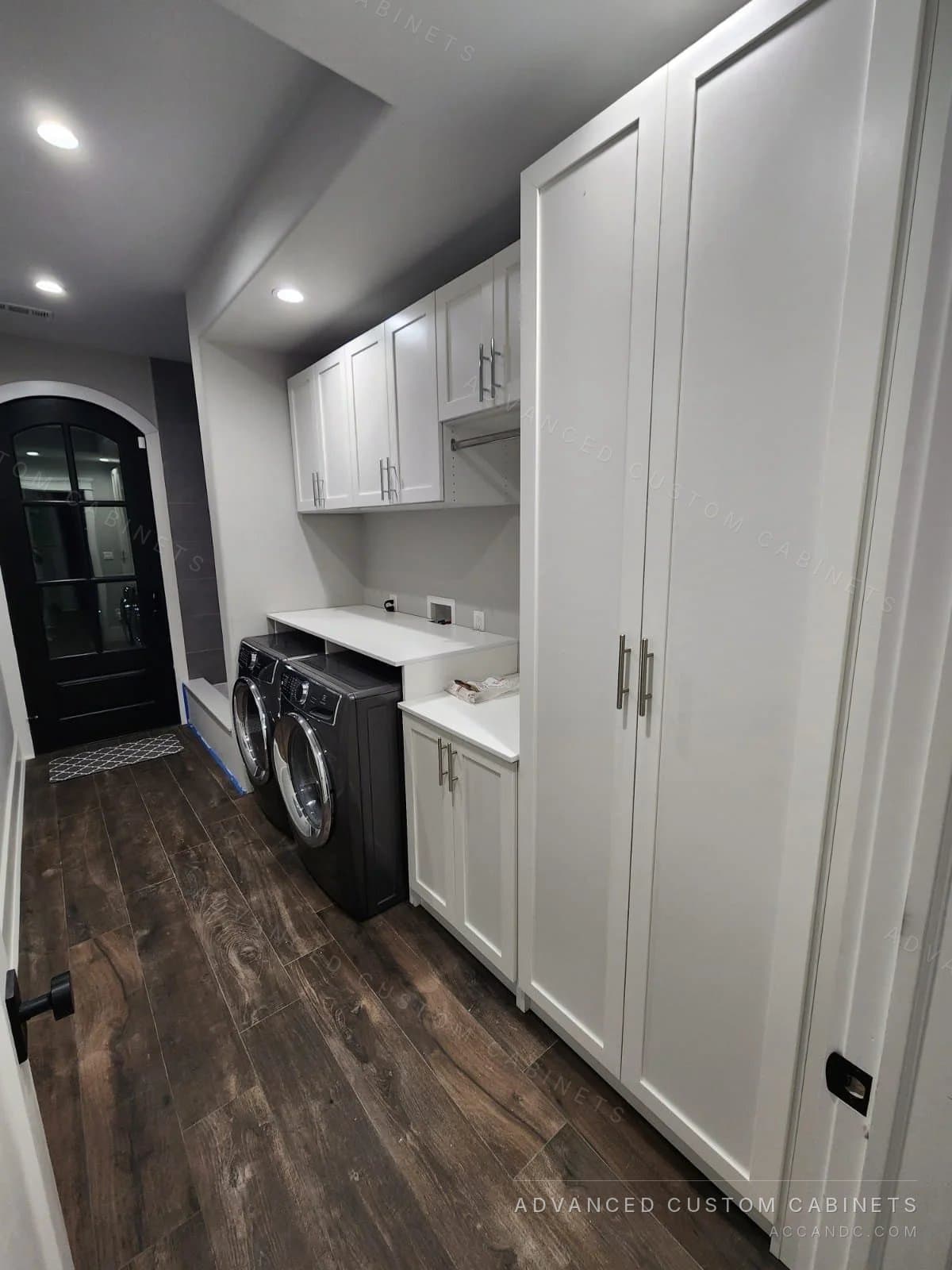 Custom laundry room with cabinets and washer-dryer