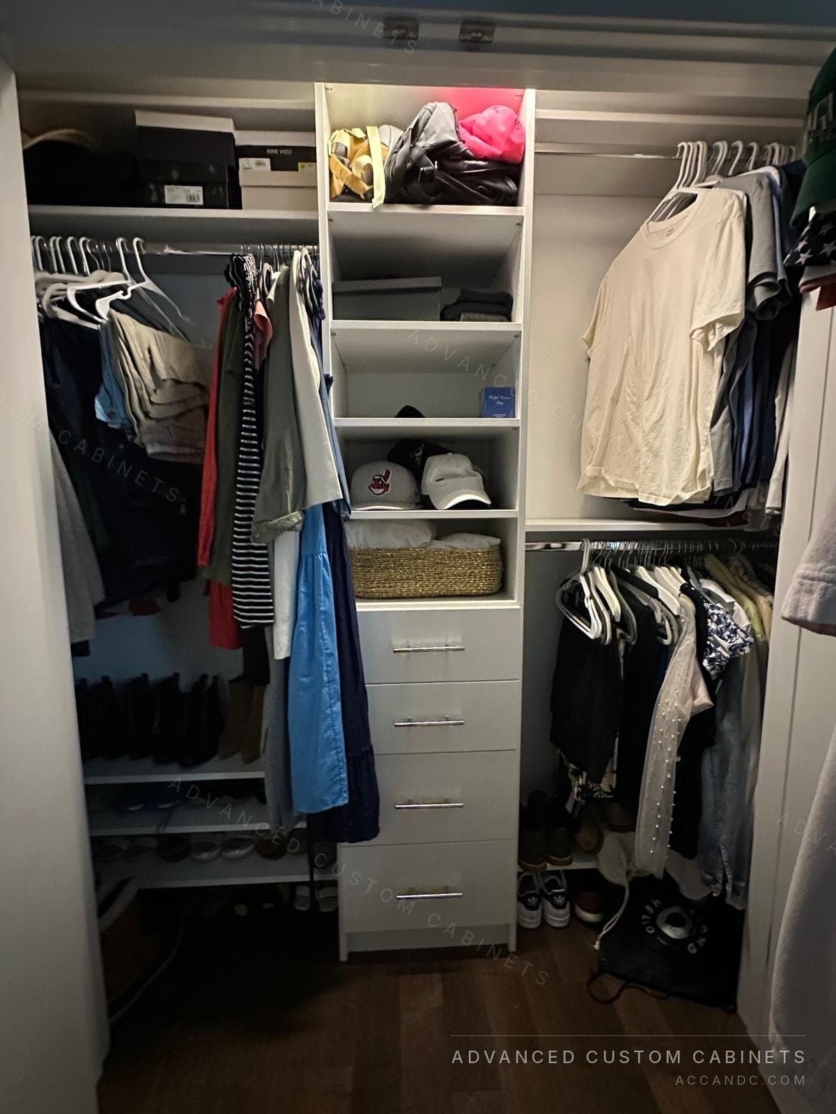 White reach-in closet with central tower, baskets, and adjustable shelves