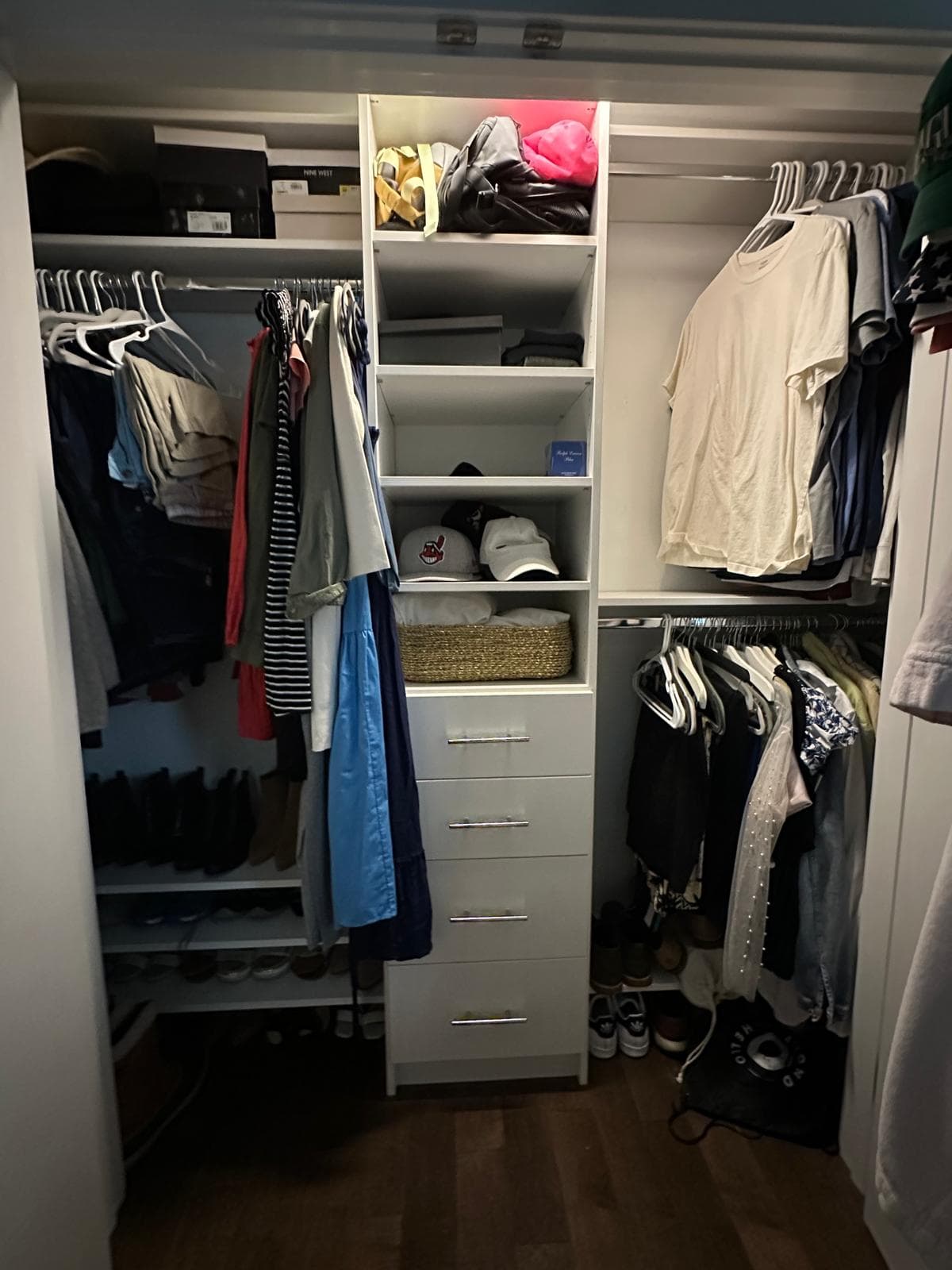White reach-in closet with central tower, baskets, and adjustable shelves