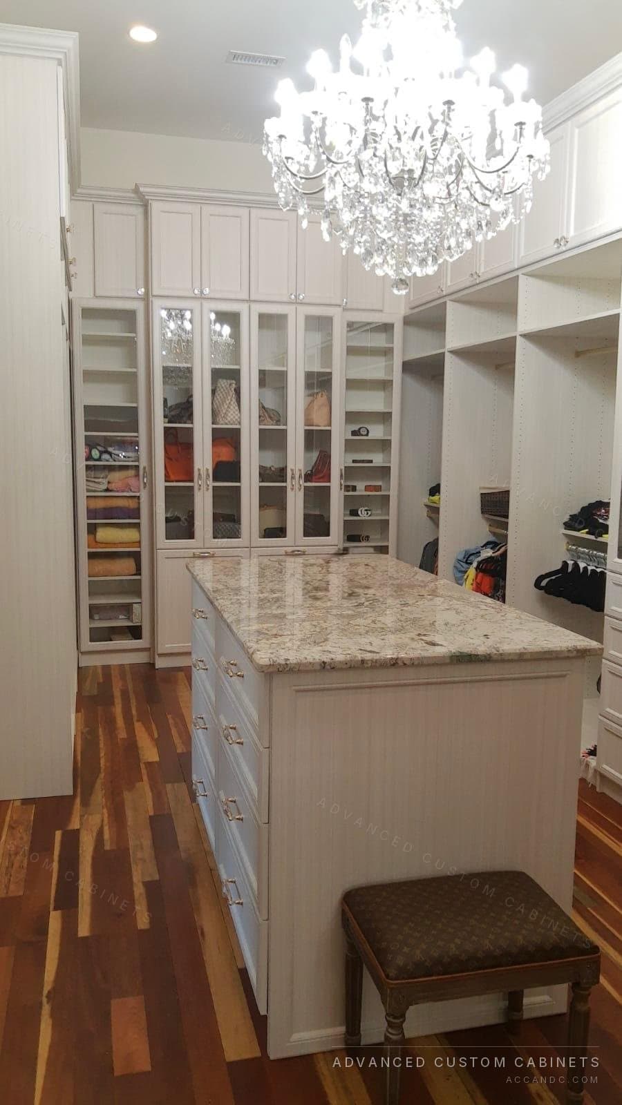 Luxury custom walk-in closet with granite-top island and crystal chandelier