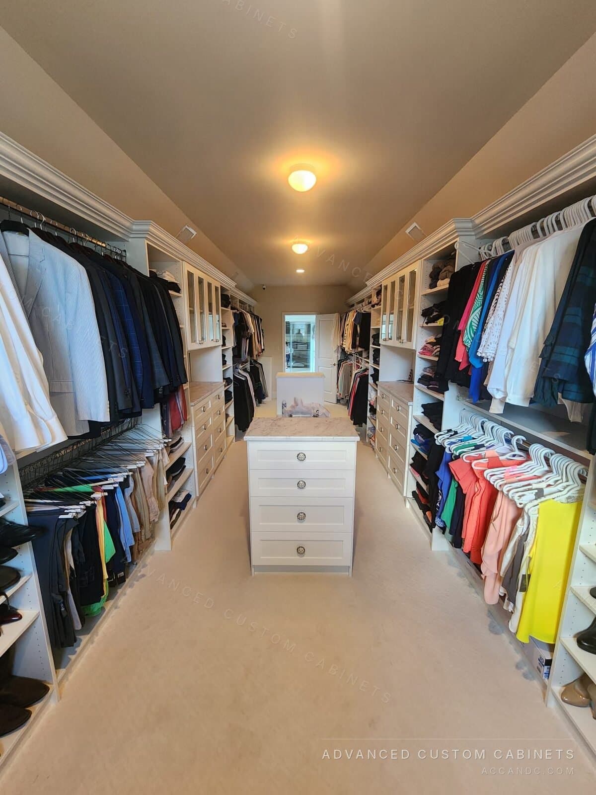 Custom walk-in closet with marble-top center island and dual-side hanging