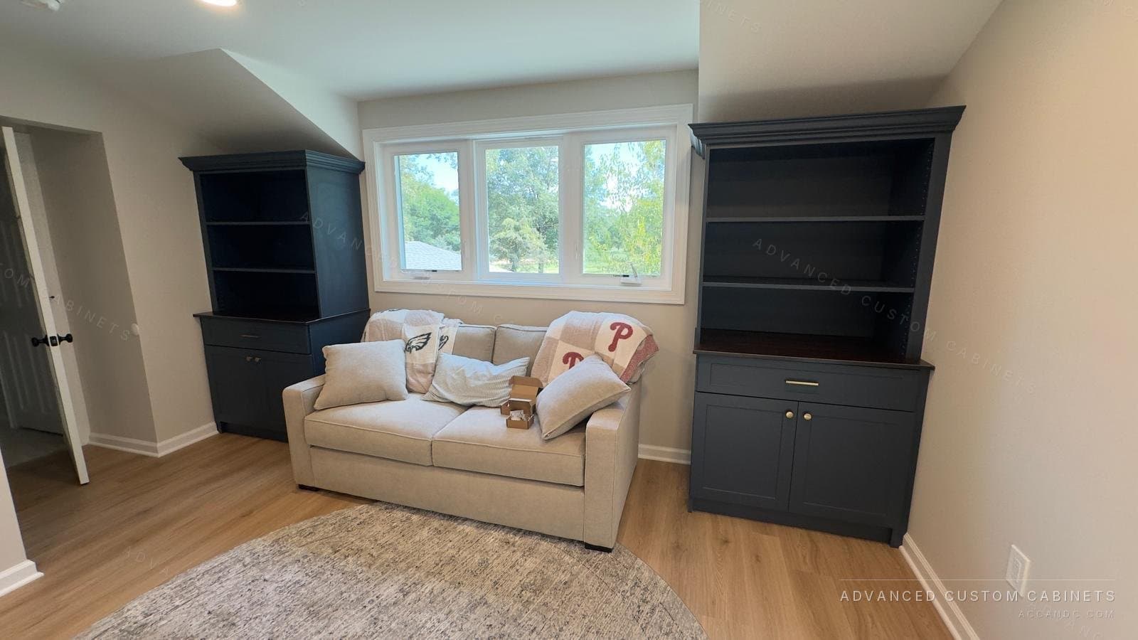 Navy blue built-in cabinets with open upper shelving on both sides of a window seating area