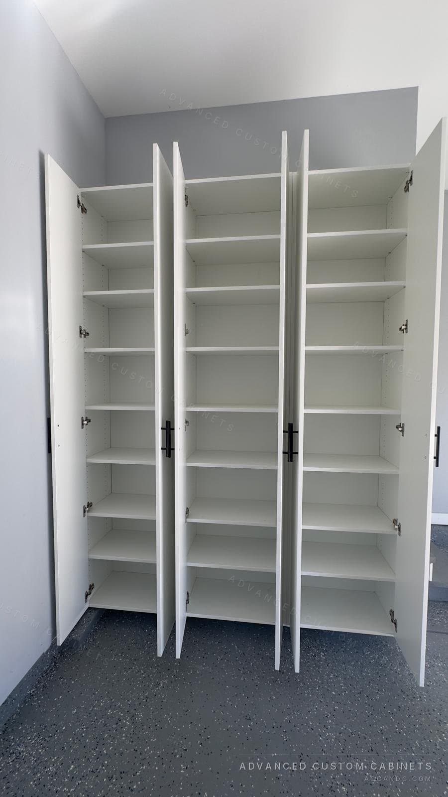 White garage storage cabinets with every door open, showing full-height adjustable shelving in all three sections