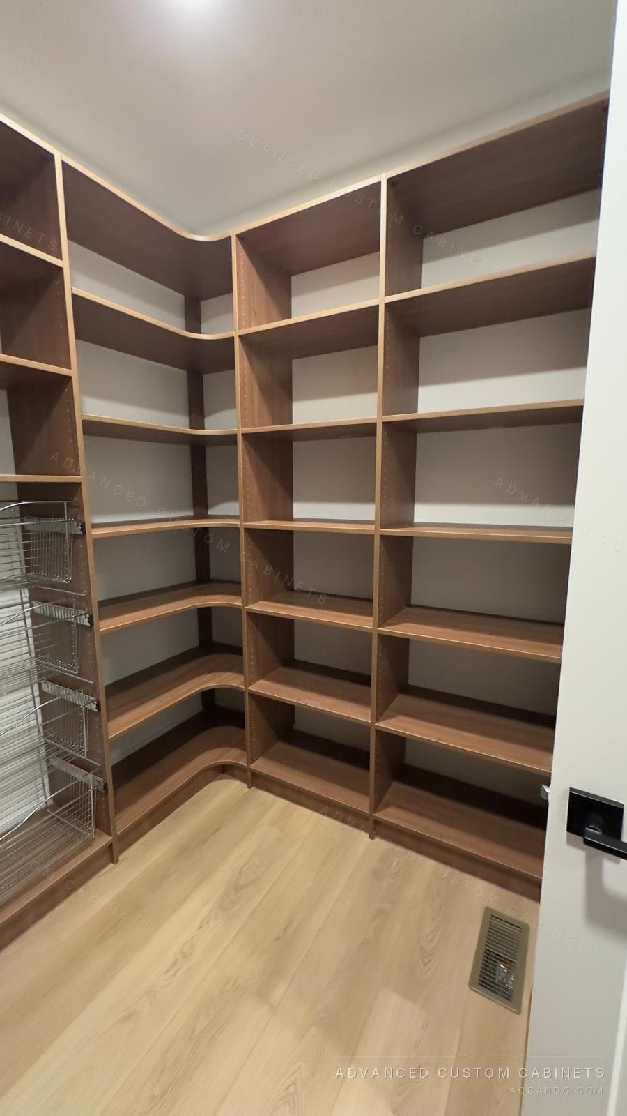 Custom walk-in pantry with wraparound wood shelving, curved corners, and a wire basket pull-out tower
