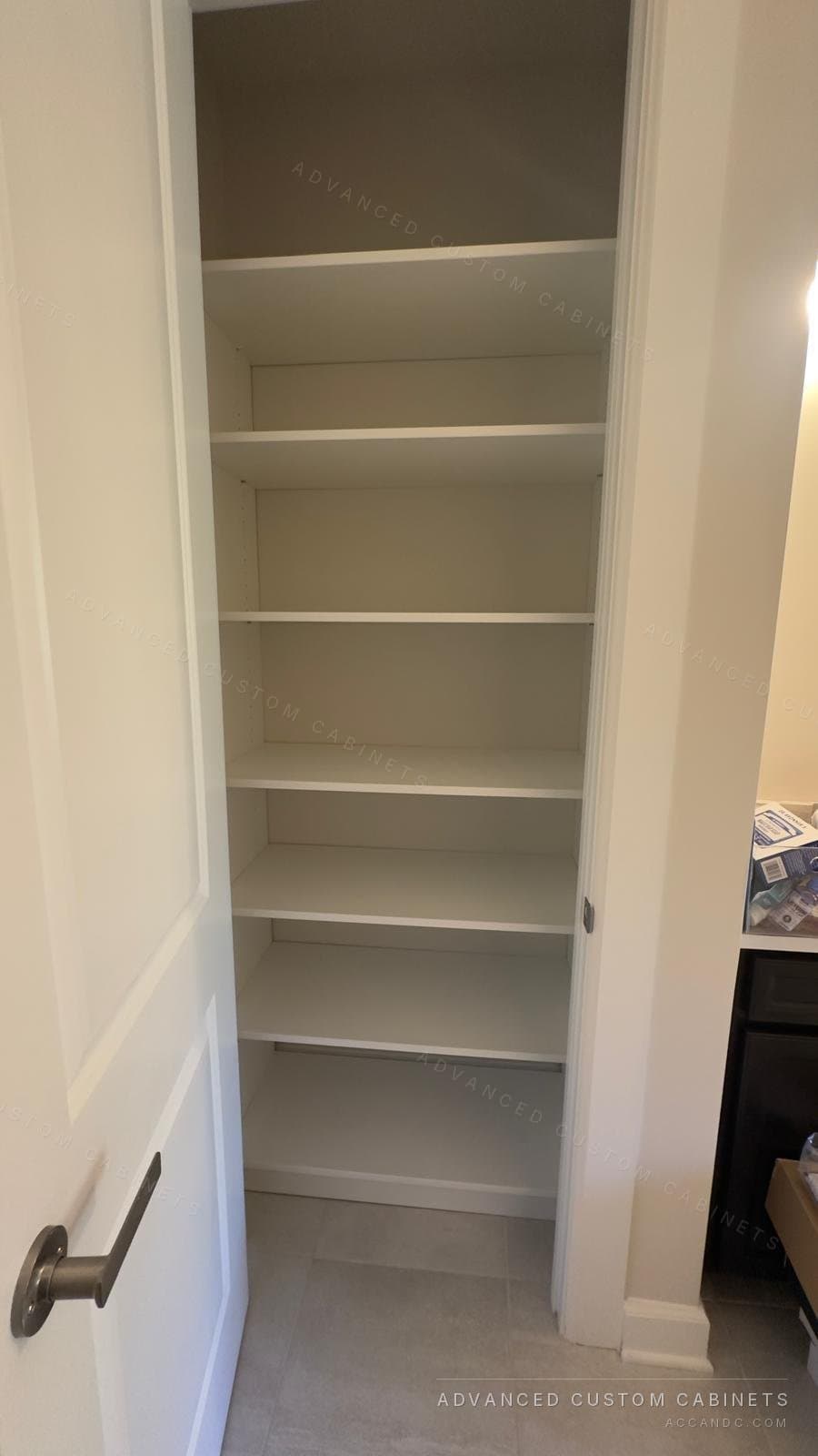 White reach-in closet with a full-height column of adjustable shelves