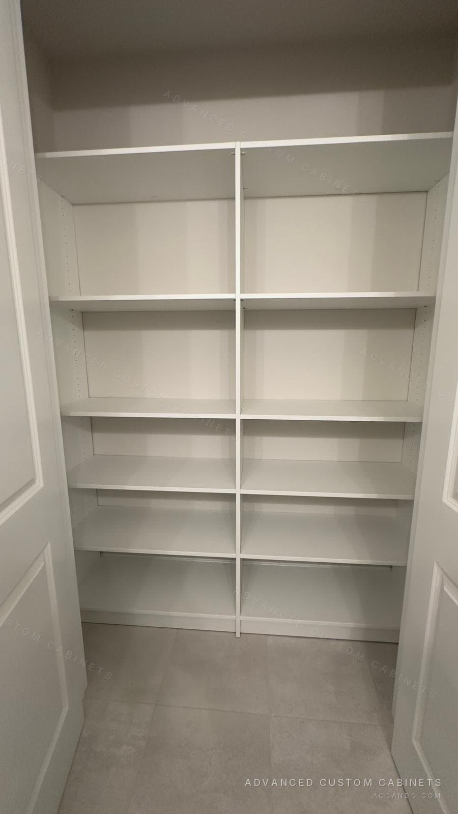 White reach-in closet with a wall of adjustable shelving from floor to ceiling