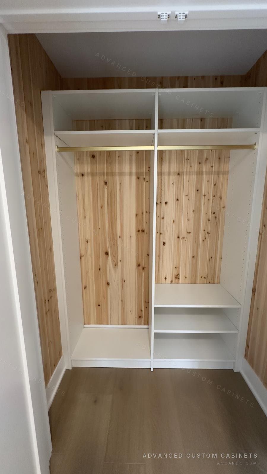 Cedar-lined reach-in closet with a full-width upper shelf, double hanging rods, and a white divider tower