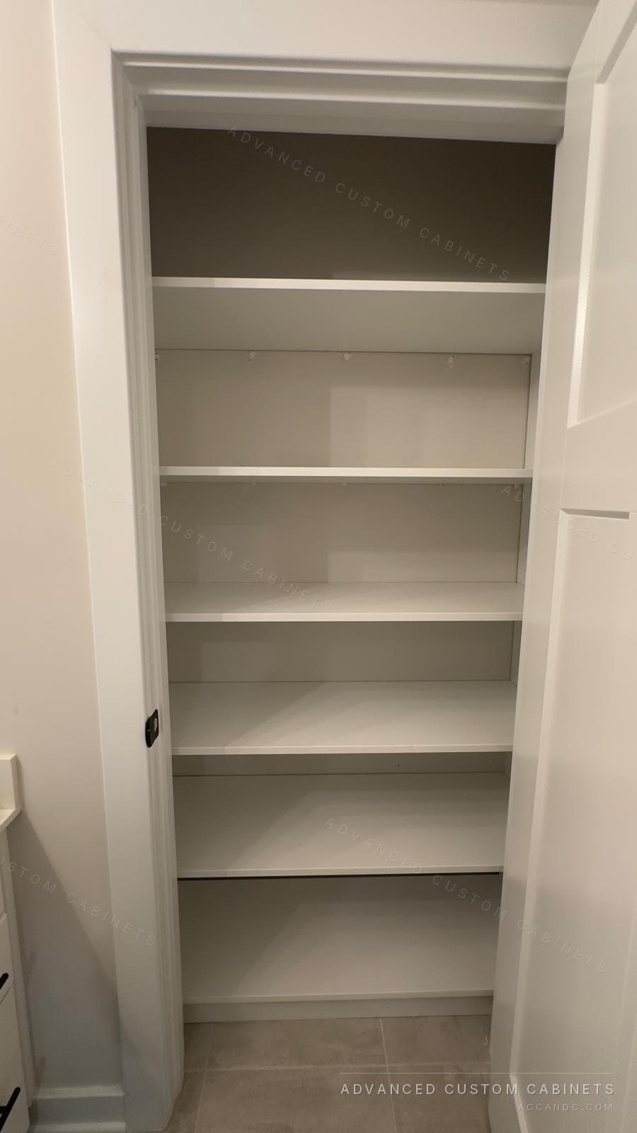 White reach-in closet lined with full-width adjustable shelves from floor to ceiling