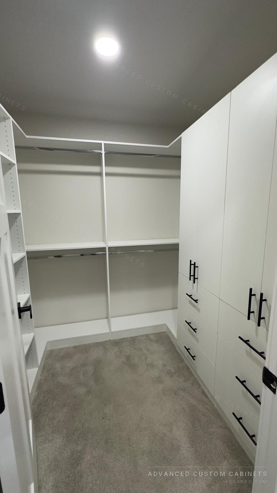White walk-in closet with corner shelving, double hanging rods and a drawer tower with black pulls