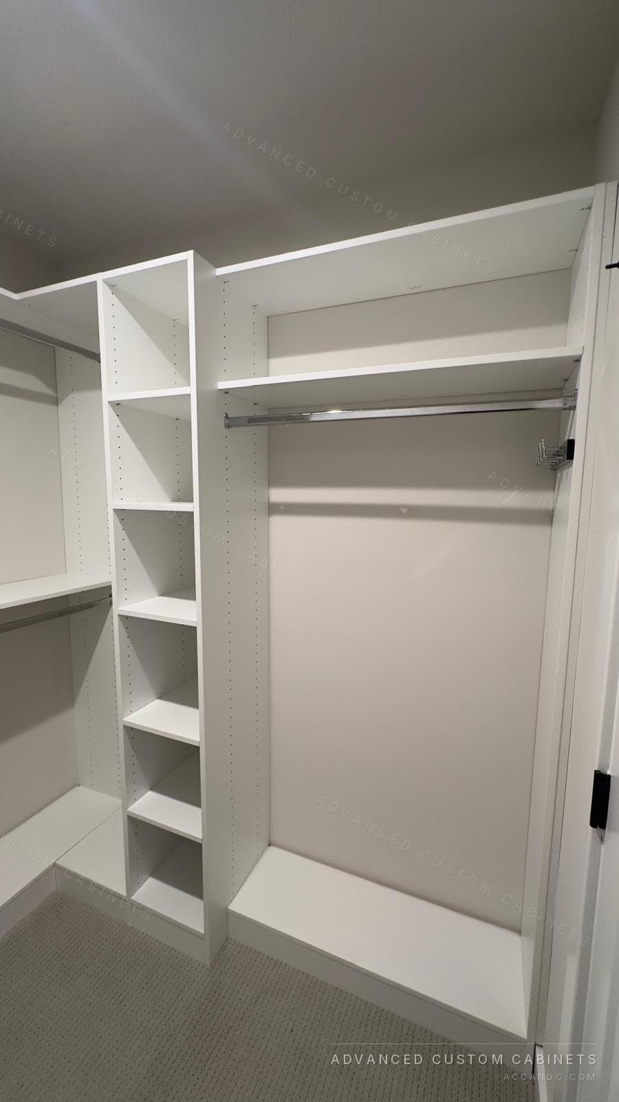 White walk-in closet with a narrow open-shelf tower between a long-hang section and a hanging rod over a shelf