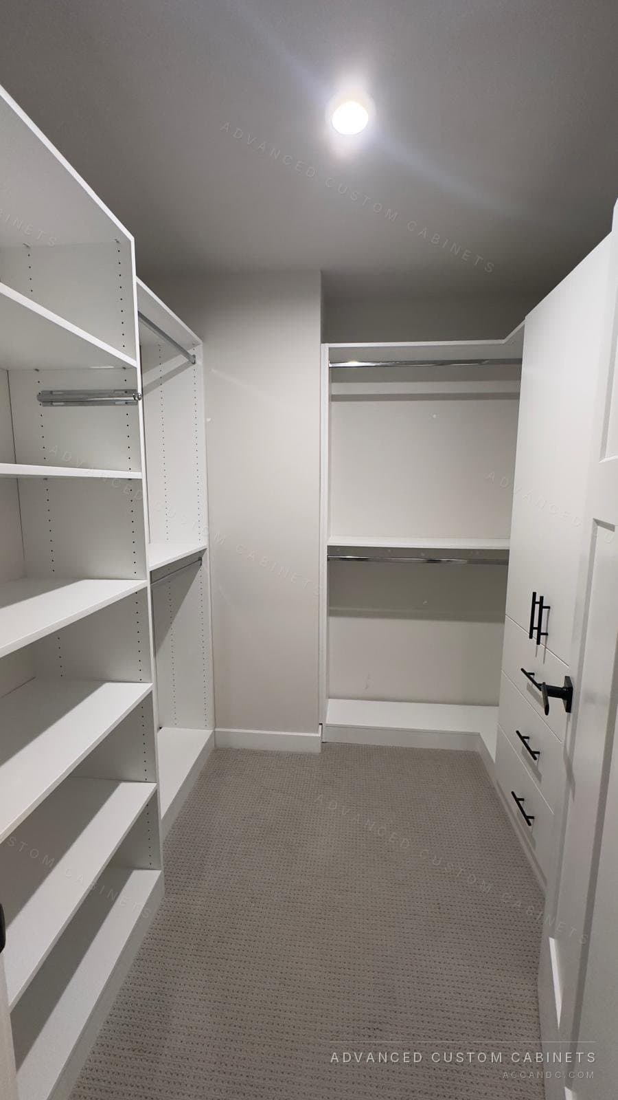 View into a white walk-in closet with open shelves and hanging rods down both sides and double hanging on the back wall