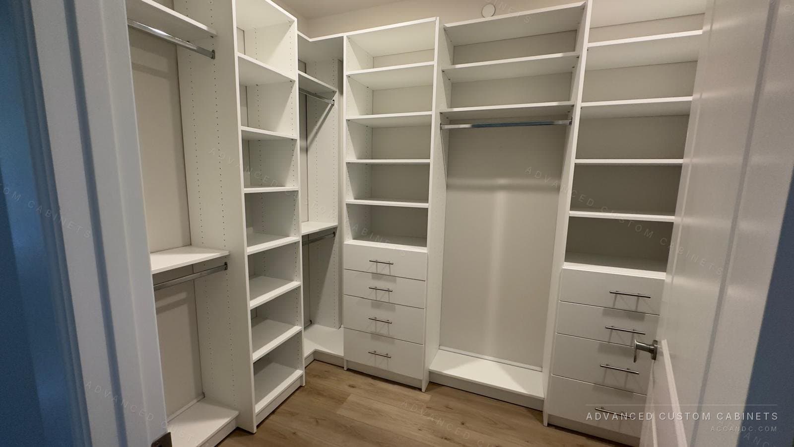 White walk-in closet with double hanging, two drawer banks with chrome pulls and open shelving