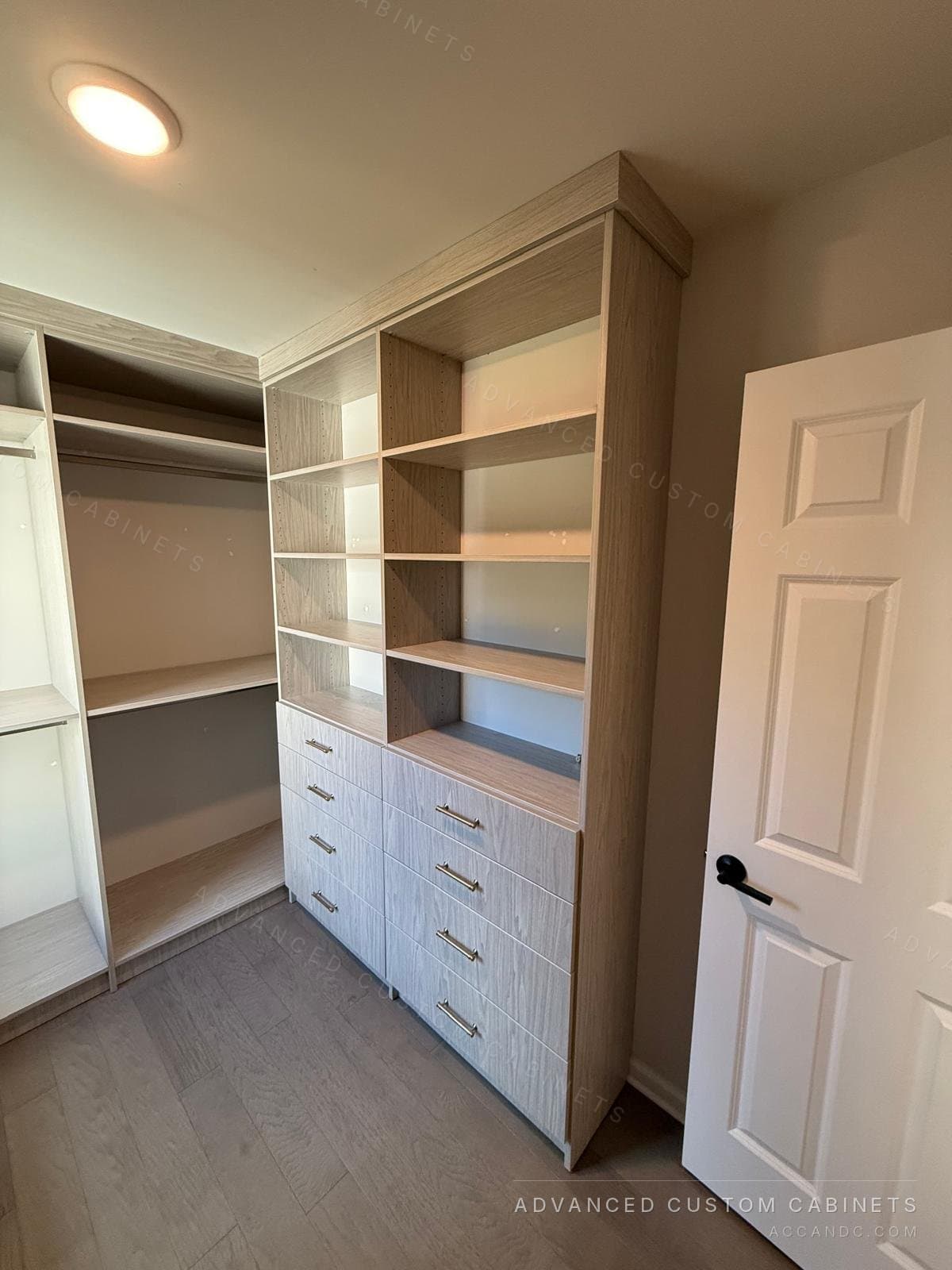 Grey-oak walk-in closet with a tall shelving tower over a six-drawer base, hanging rods and open shelves