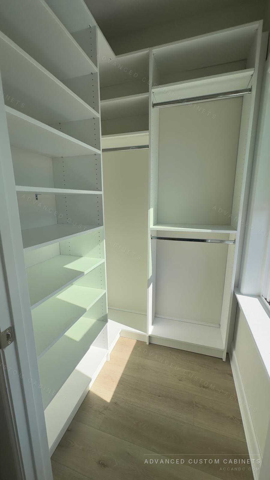 White walk-in closet with slanted shoe shelves, a shelving tower and double hanging rods