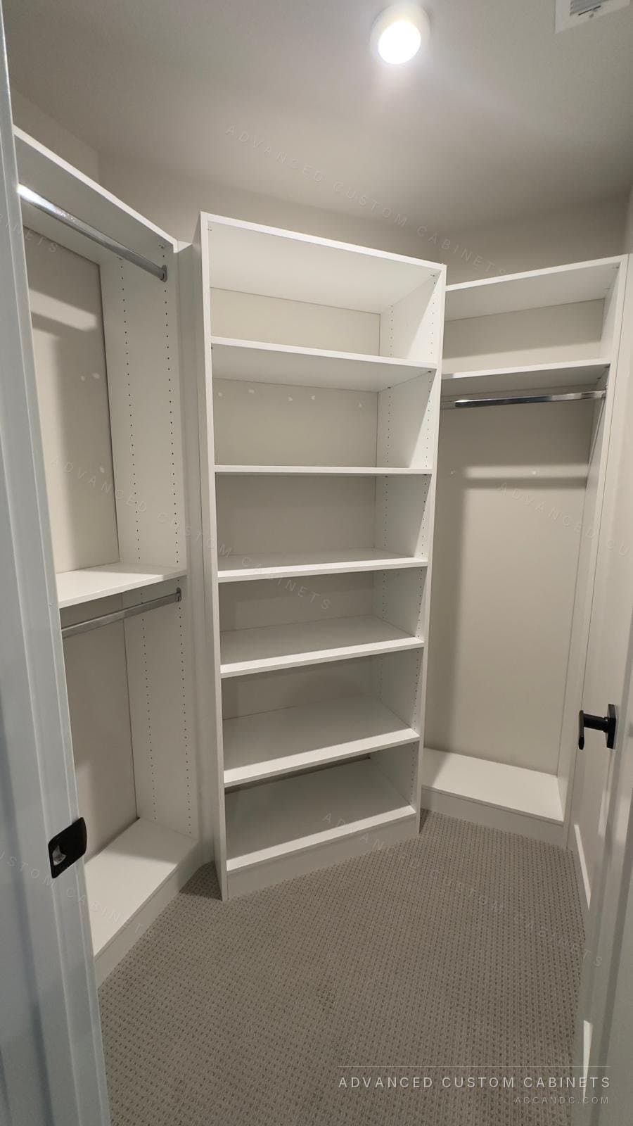 White walk-in closet with an open-shelf tower in the middle, double hanging on the left and a long-hang corner section