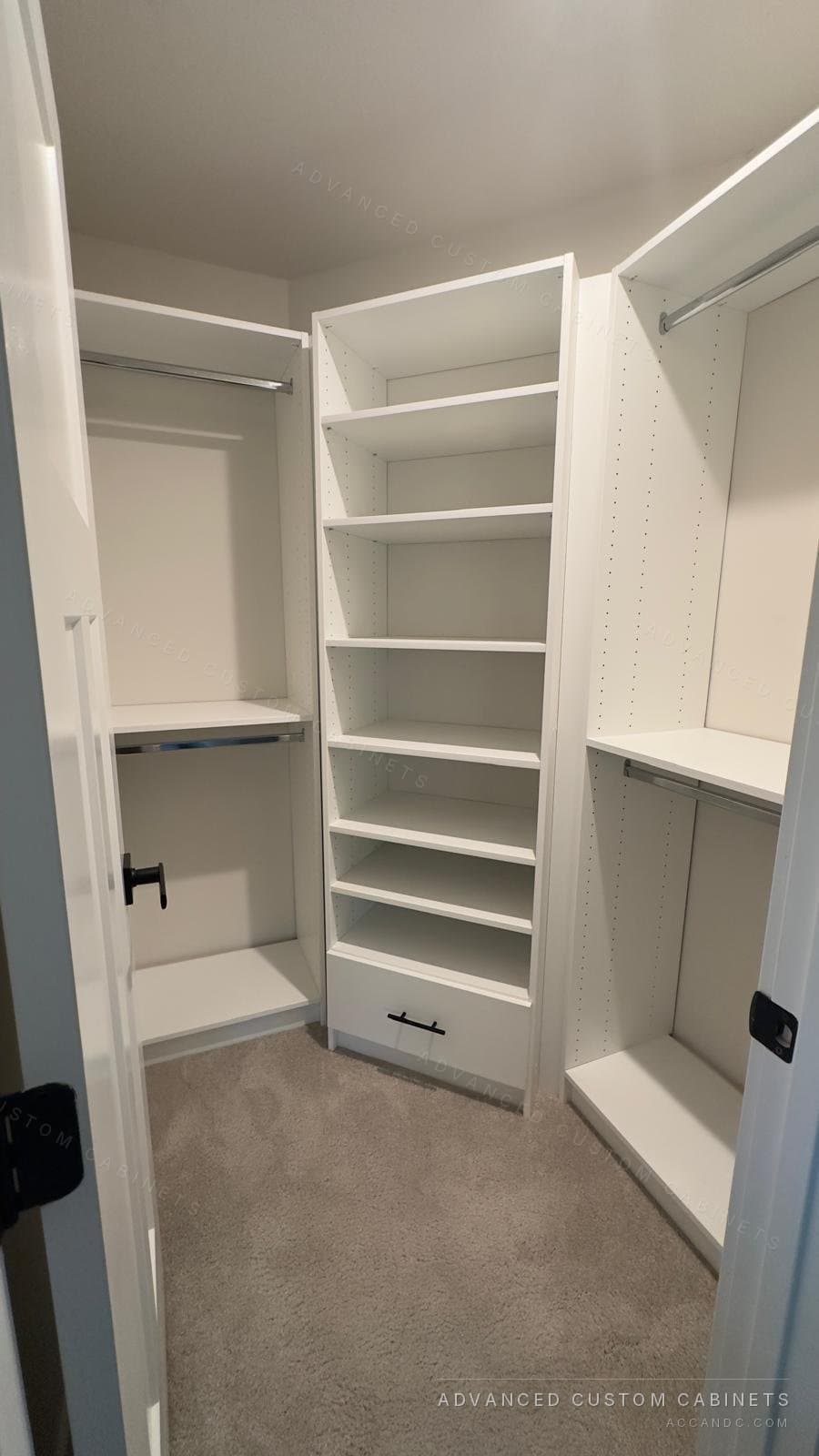 Small white walk-in closet with a shelving tower over a drawer, double hanging on the left and a long-hang section beside the door