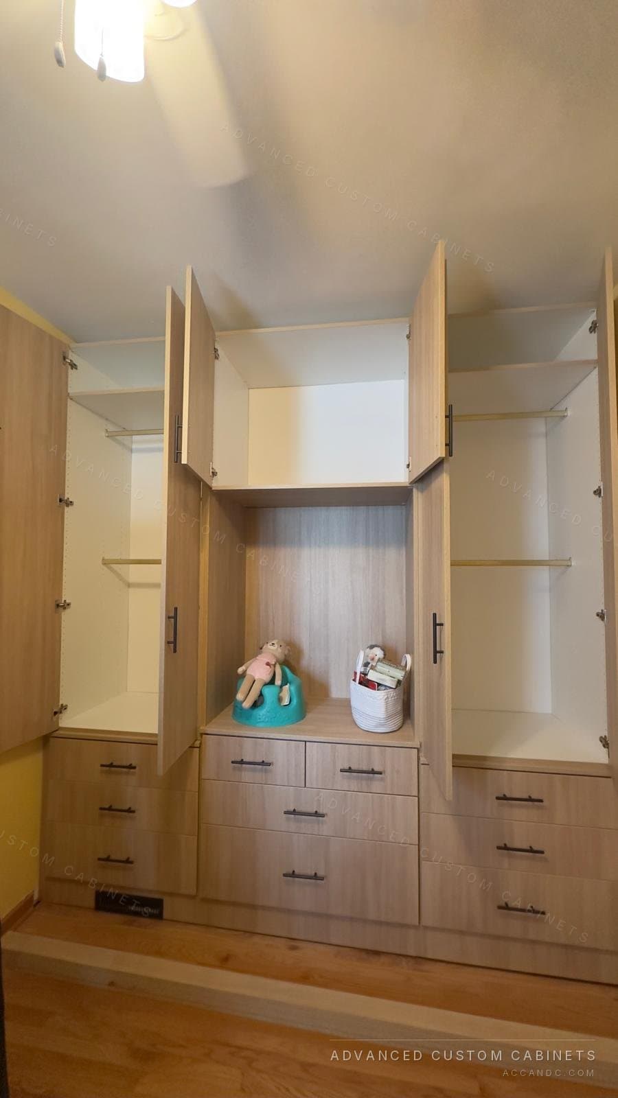 Oak-finish wardrobe unit with the doors open, showing hanging rods, upper shelves and an open centre niche over drawers