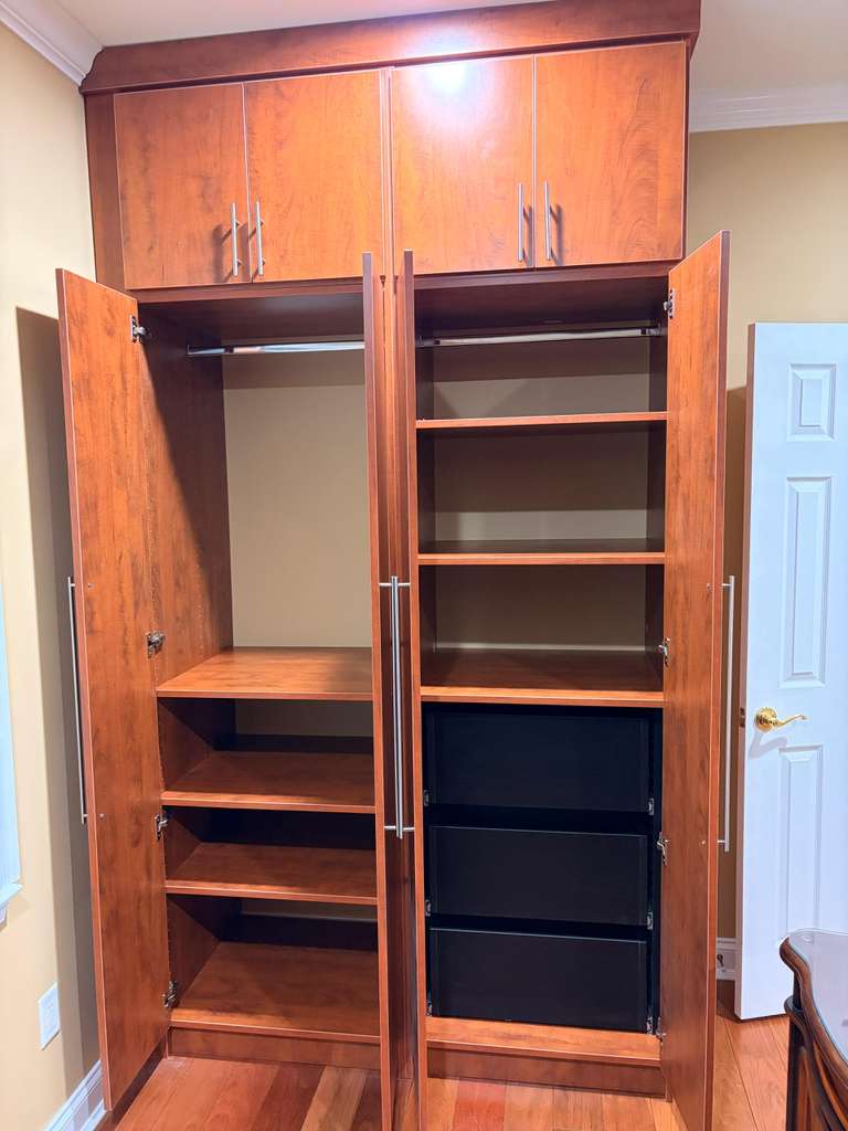 Custom cherry-finish wardrobe interior with adjustable shelves, hanging rods and pull-out drawers