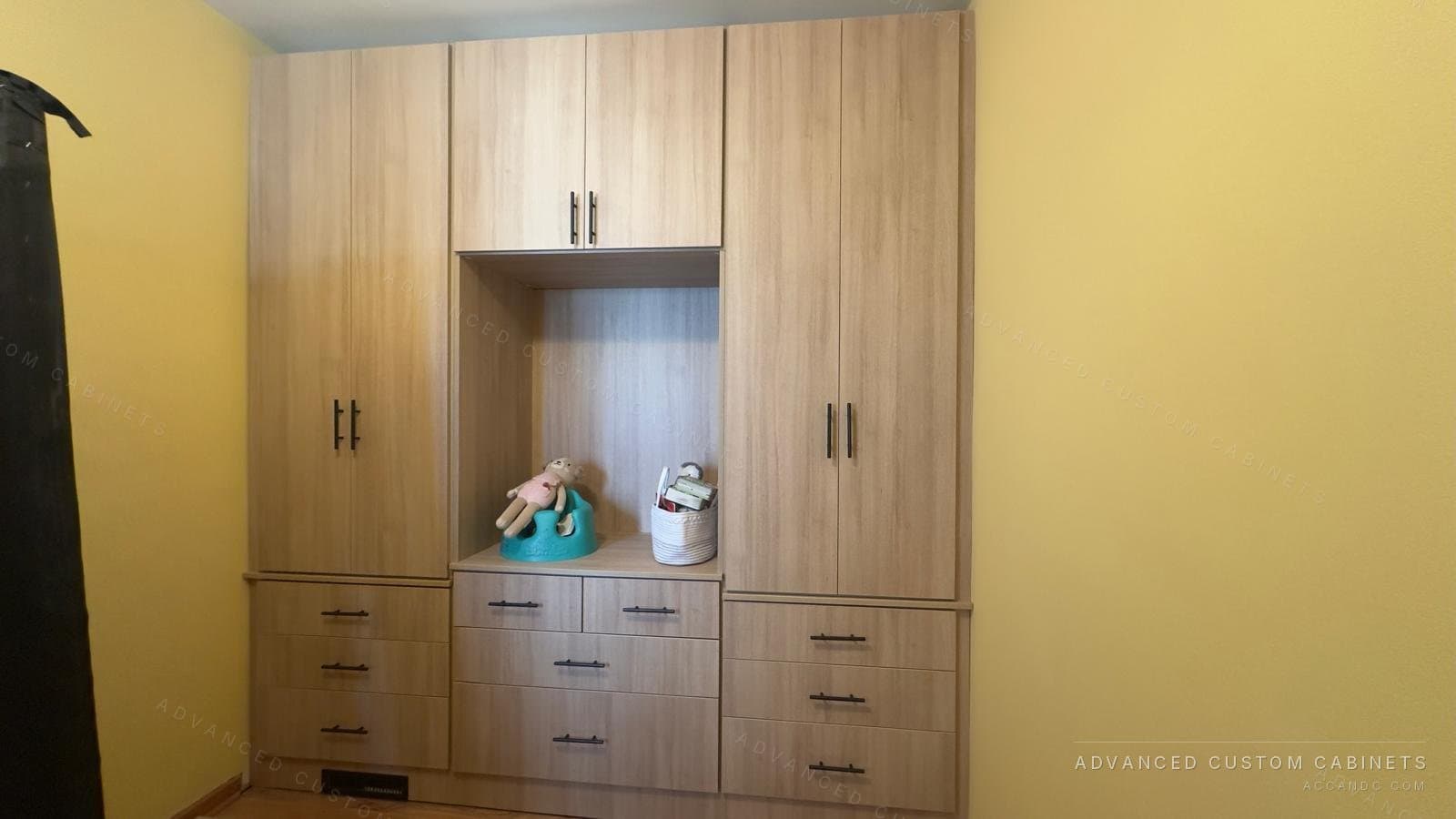 Oak-finish wardrobe unit with two tall double-door towers, an open centre niche and drawer bases with black pulls