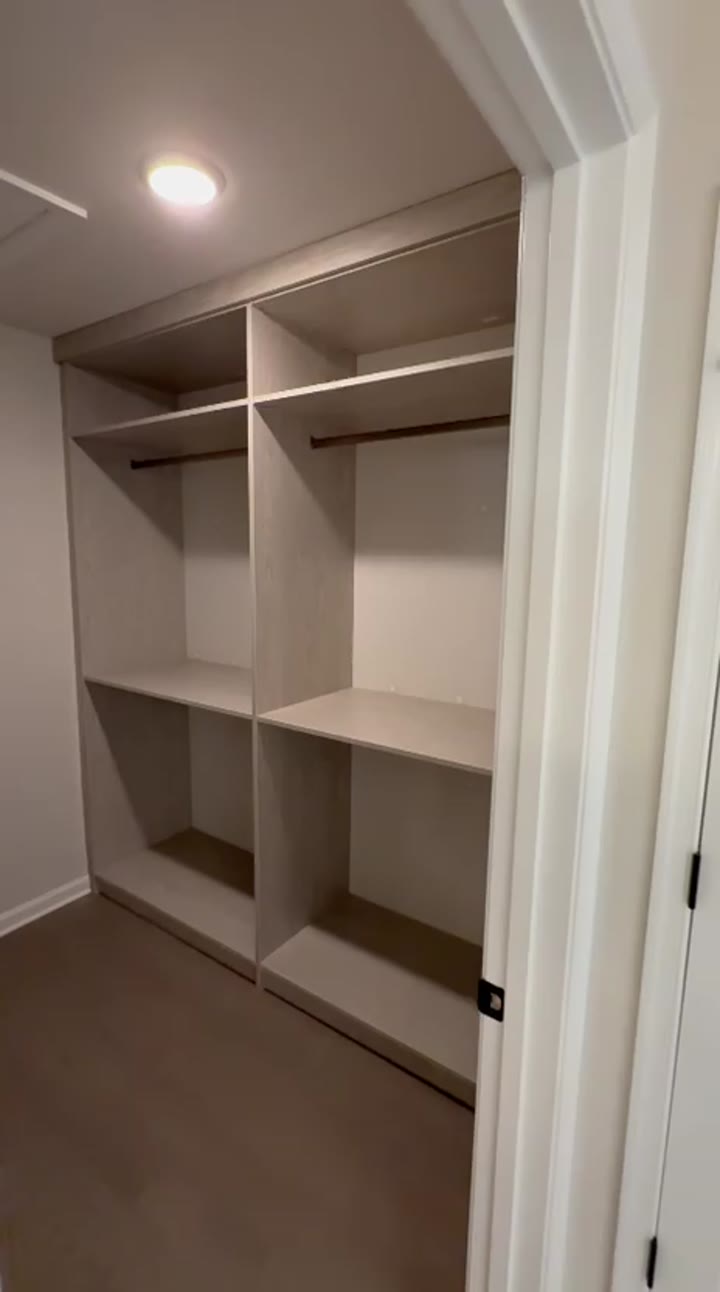 Grey-oak walk-in closet with hanging sections and open shelves beside the door, video walkthrough
